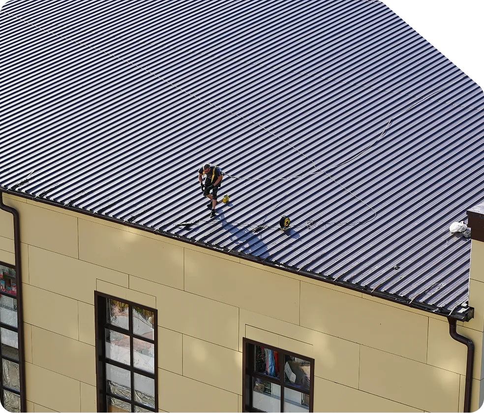 Ouvrier travaillant sur un toit métallique sécurisé